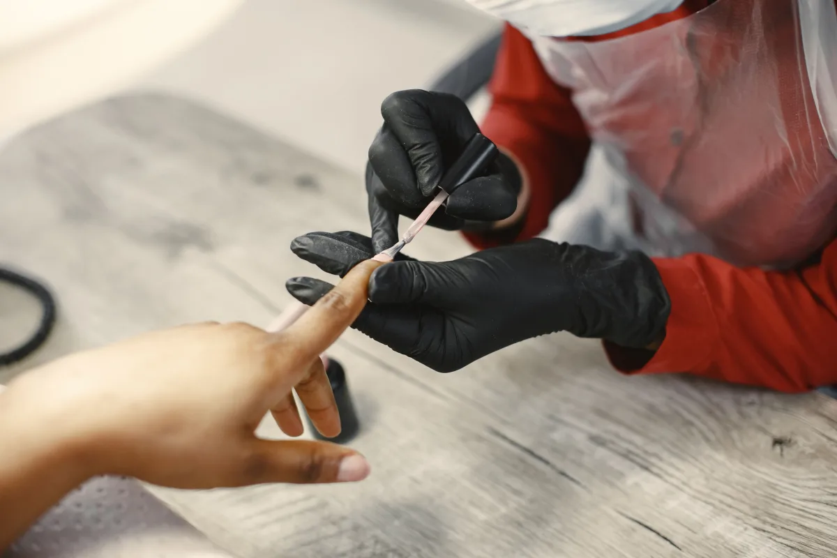 Nail artist applying gel polish with professional technique