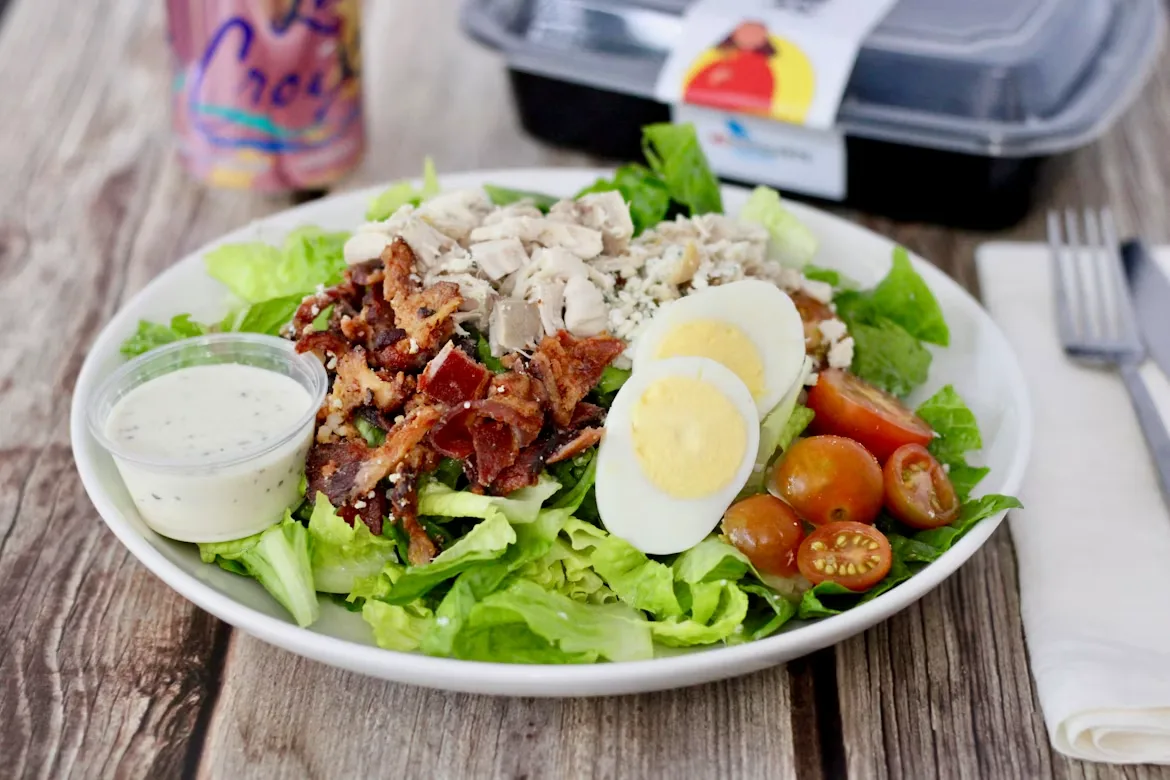 Ready-to-eat healthy salad on a white ceramic plate — food delivery service