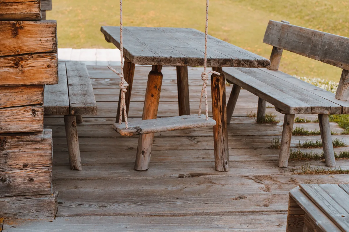 Wooden bench on sunny patio representing low-maintenance poly lumber style