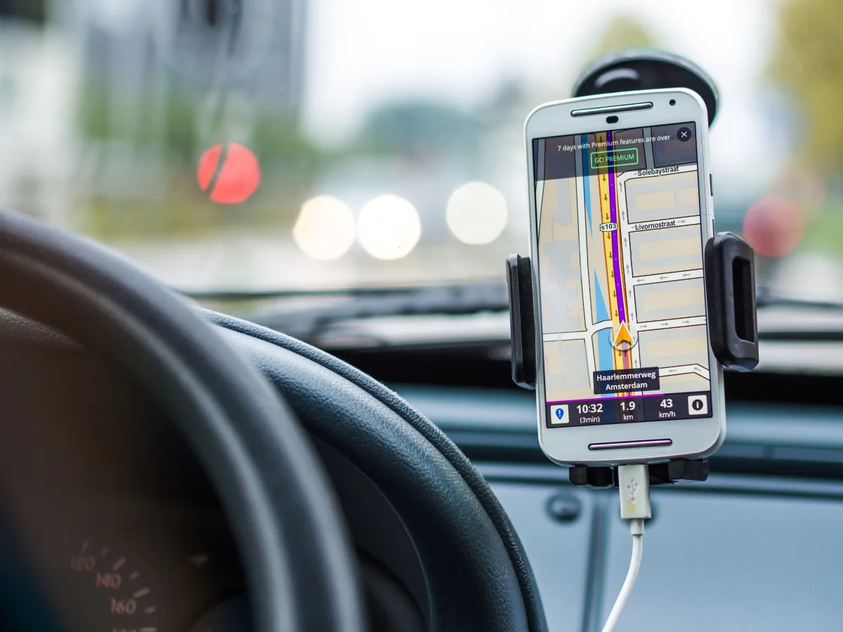 Standalone GPS device mounted on car windshield showing route map