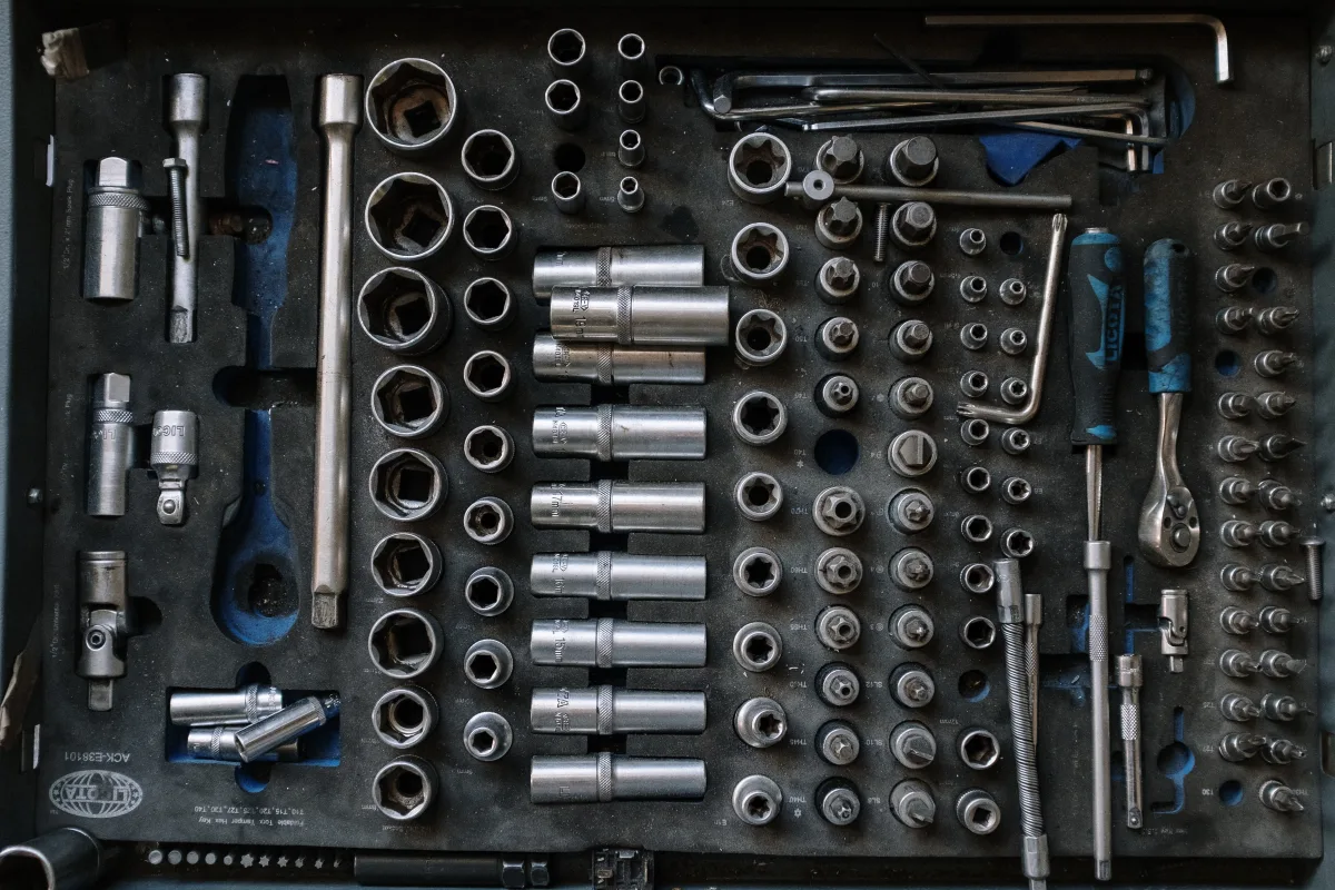 Flat lay of hand tools and sockets on a workshop surface