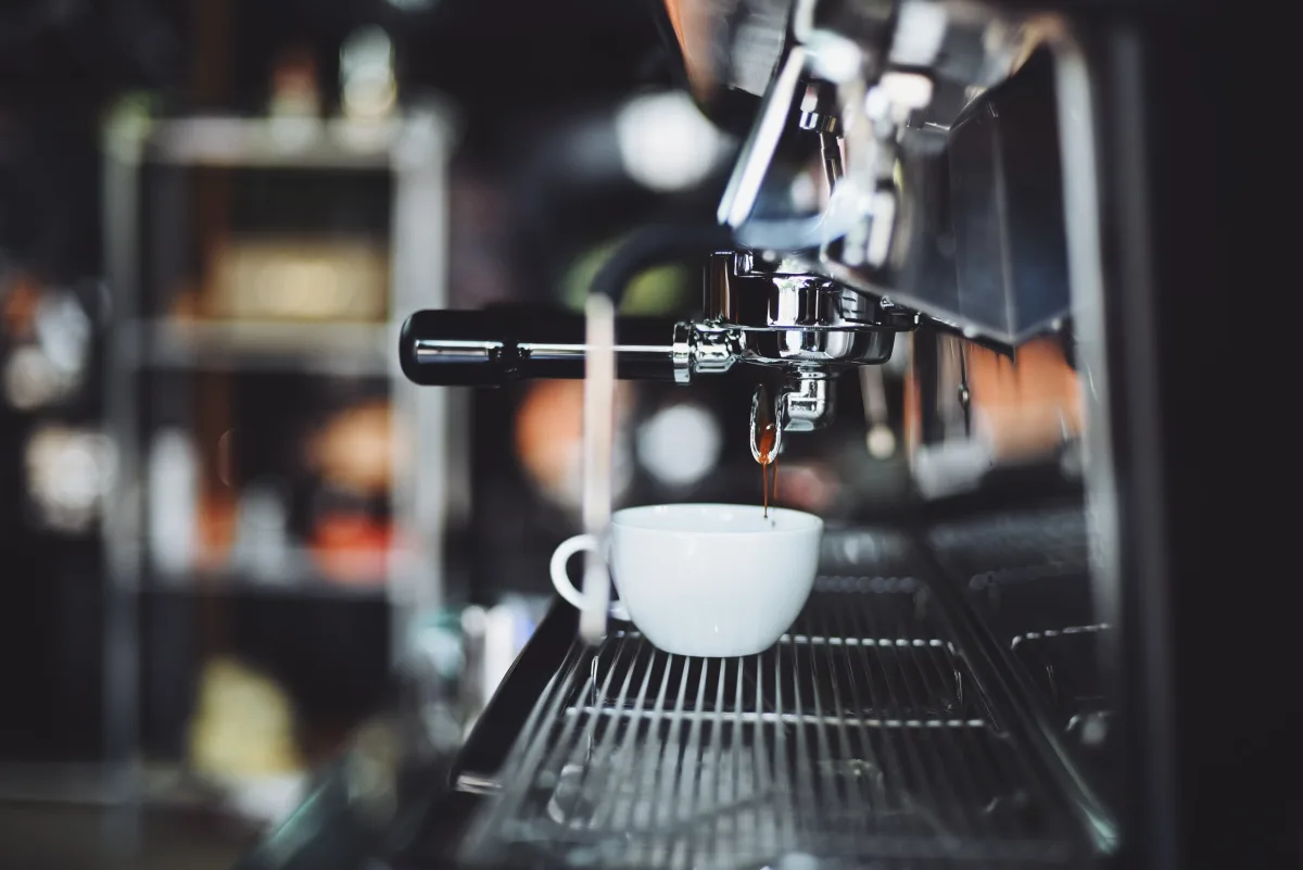Close-up of espresso machine brewing coffee into a white cup — best budget espresso machines 2026