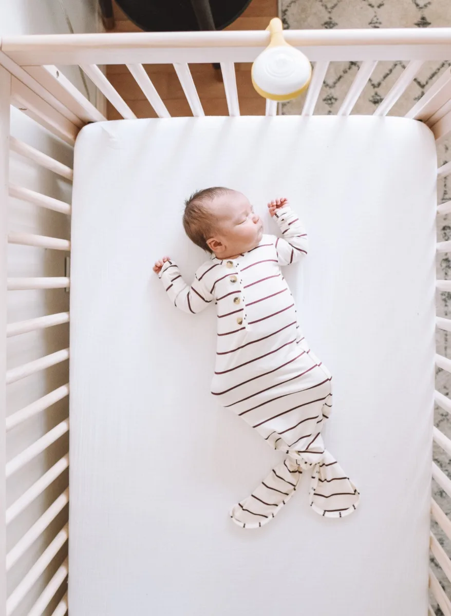 White video baby monitor parent unit on a wooden nursery shelf