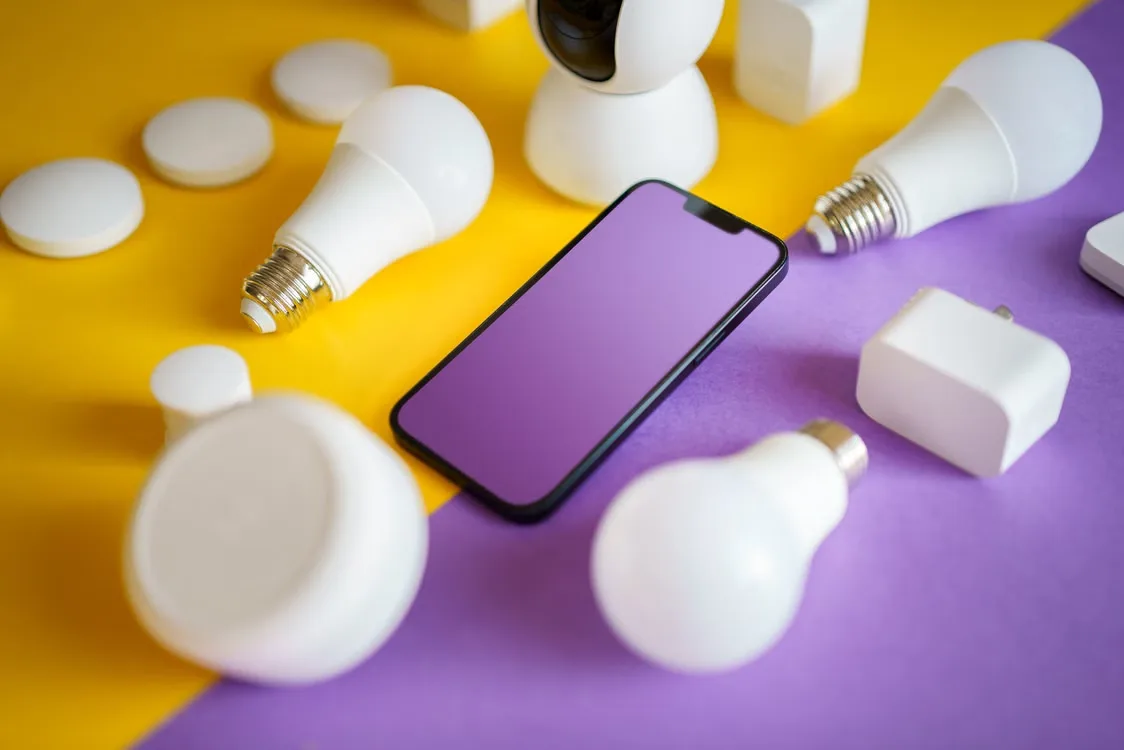 Colorful flat lay of smart home devices and a smartphone on vivid background