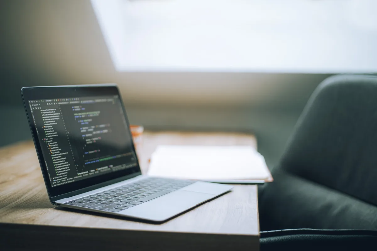 Open laptop on a desk in a bright modern office representing a hybrid-team focus zone
