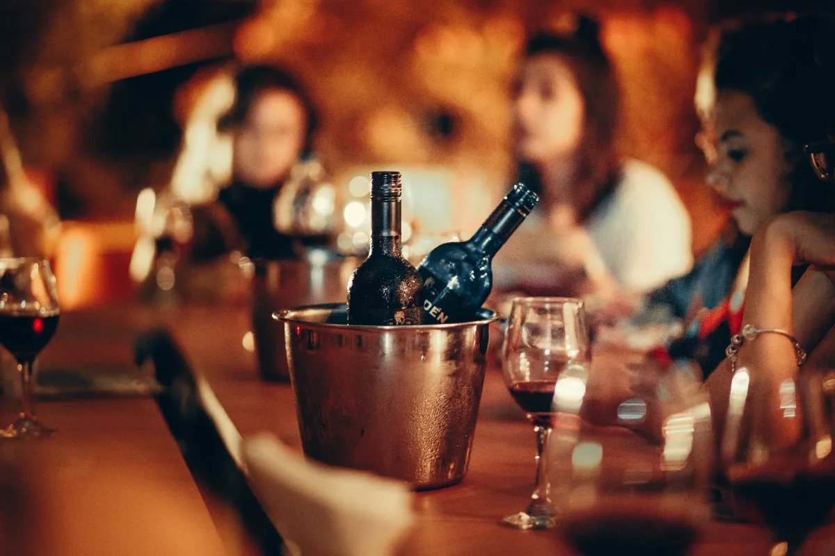 Wine bottles and glasses arranged on a bar counter for tasting