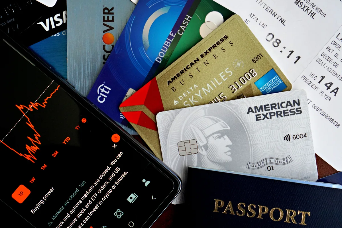 Flat lay of credit cards, passport, and smartphone showing travel data