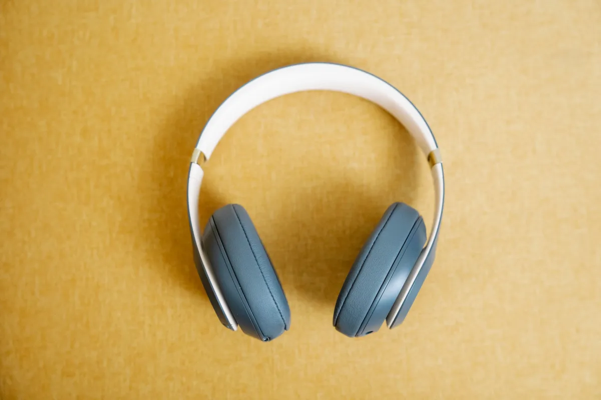 Blue wireless headphones on a yellow background
