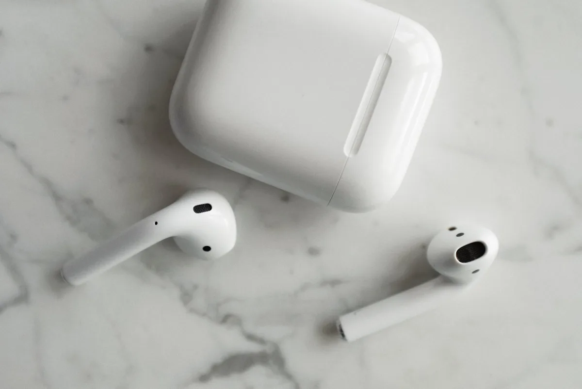 Wireless earbuds and charging case on a marble surface
