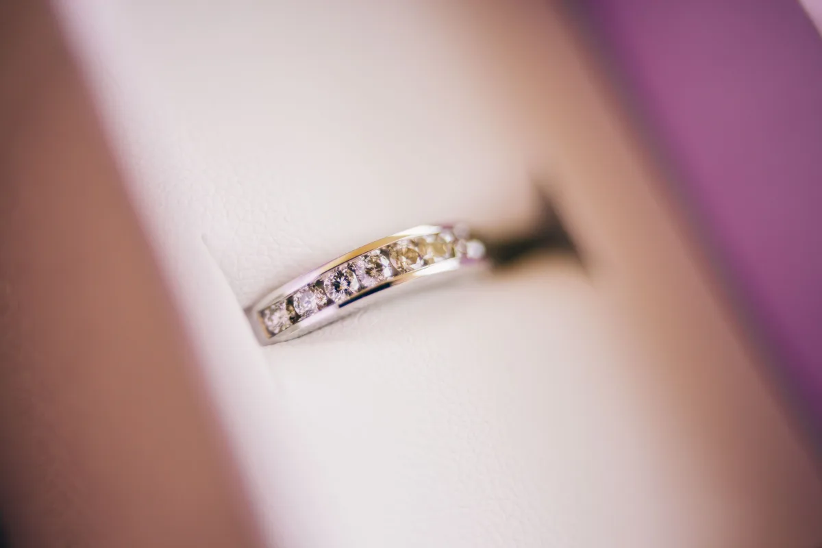 Macro photograph of a diamond wedding ring in soft lighting showing luxury detail