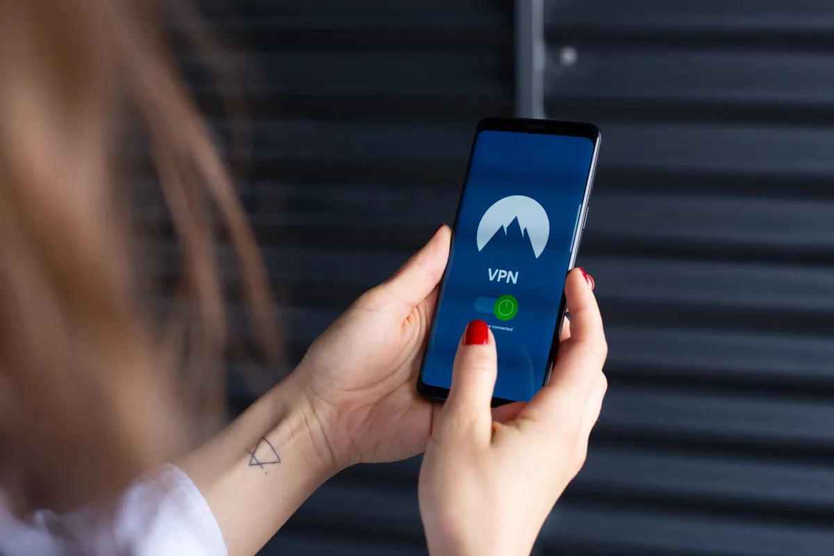 Close-up of hands using a VPN app on a smartphone showing secure connection
