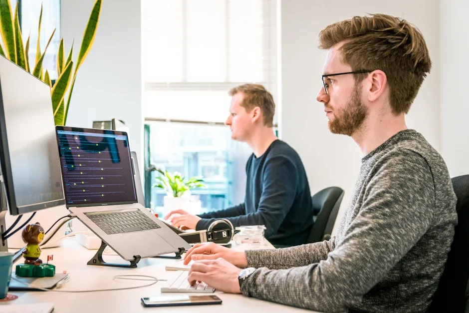 Small business team reviewing CRM pipeline on laptops in a modern office