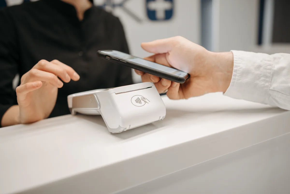 Person making contactless payment using smartphone at retail counter