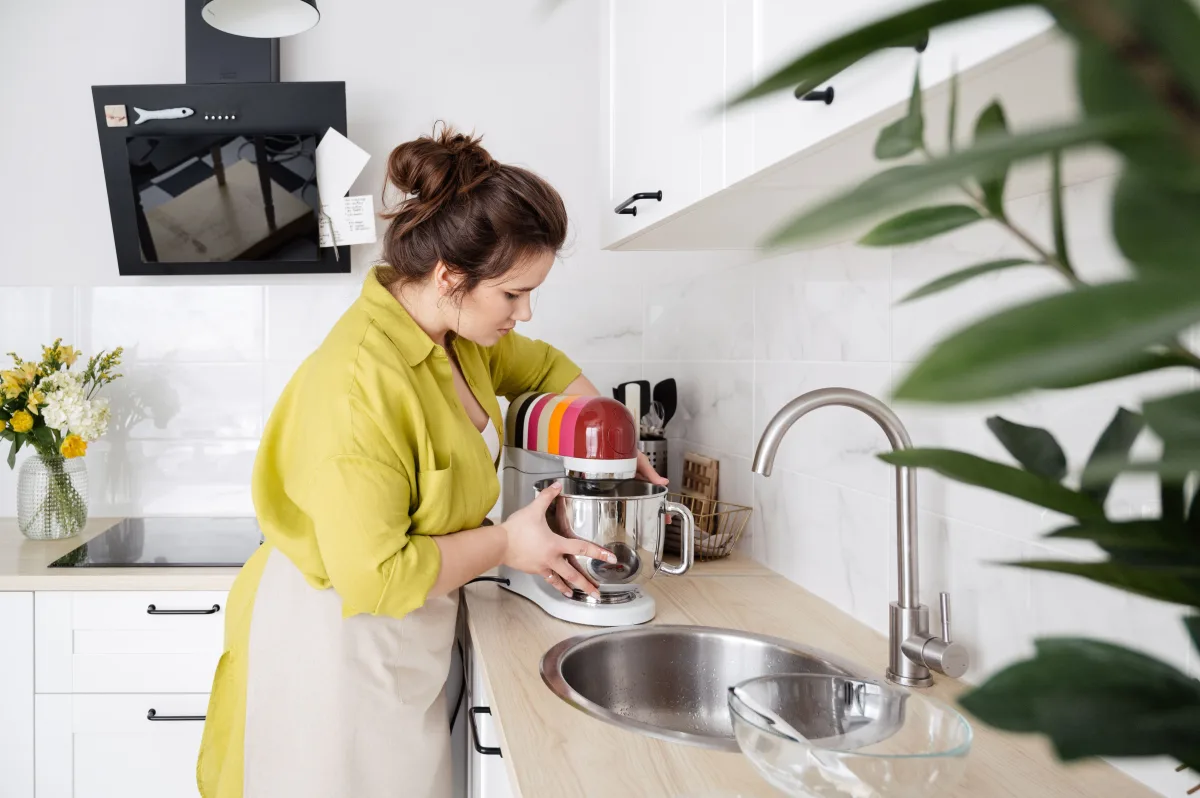 Woman using a stand mixer to mix batter in a modern kitchen