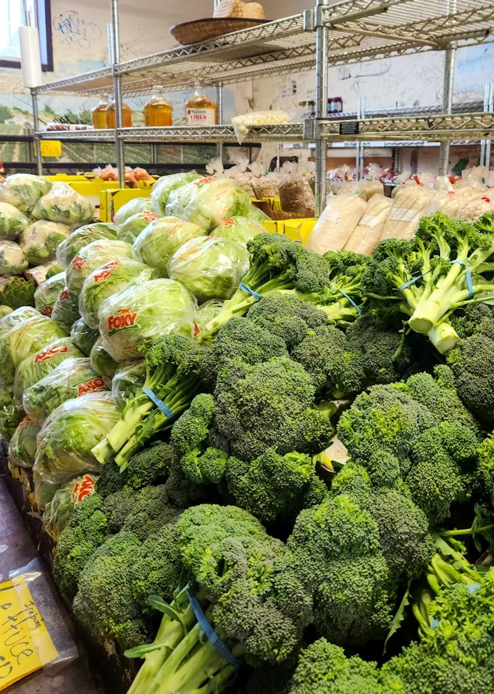 Fresh broccoli and lettuce displayed at a grocery store produce section