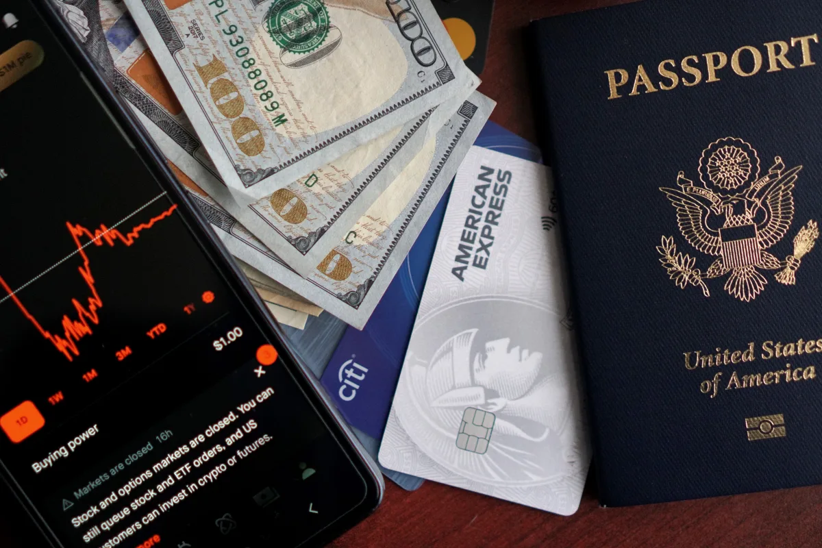 Stock trading concepts with passport, credit cards, cash, and smartphone app