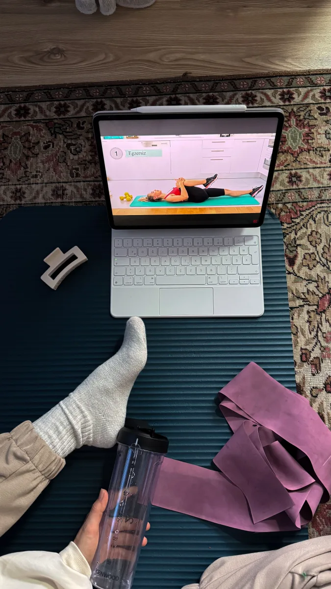 Woman doing home workout with laptop showing online fitness class