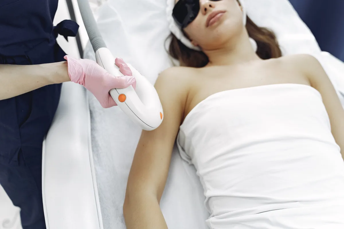 Esthetician in gloves performing laser treatment in a professional salon setting