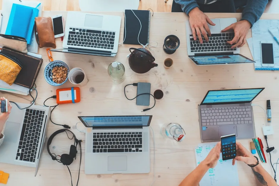 Team members at a conference table with open laptops in a startup office