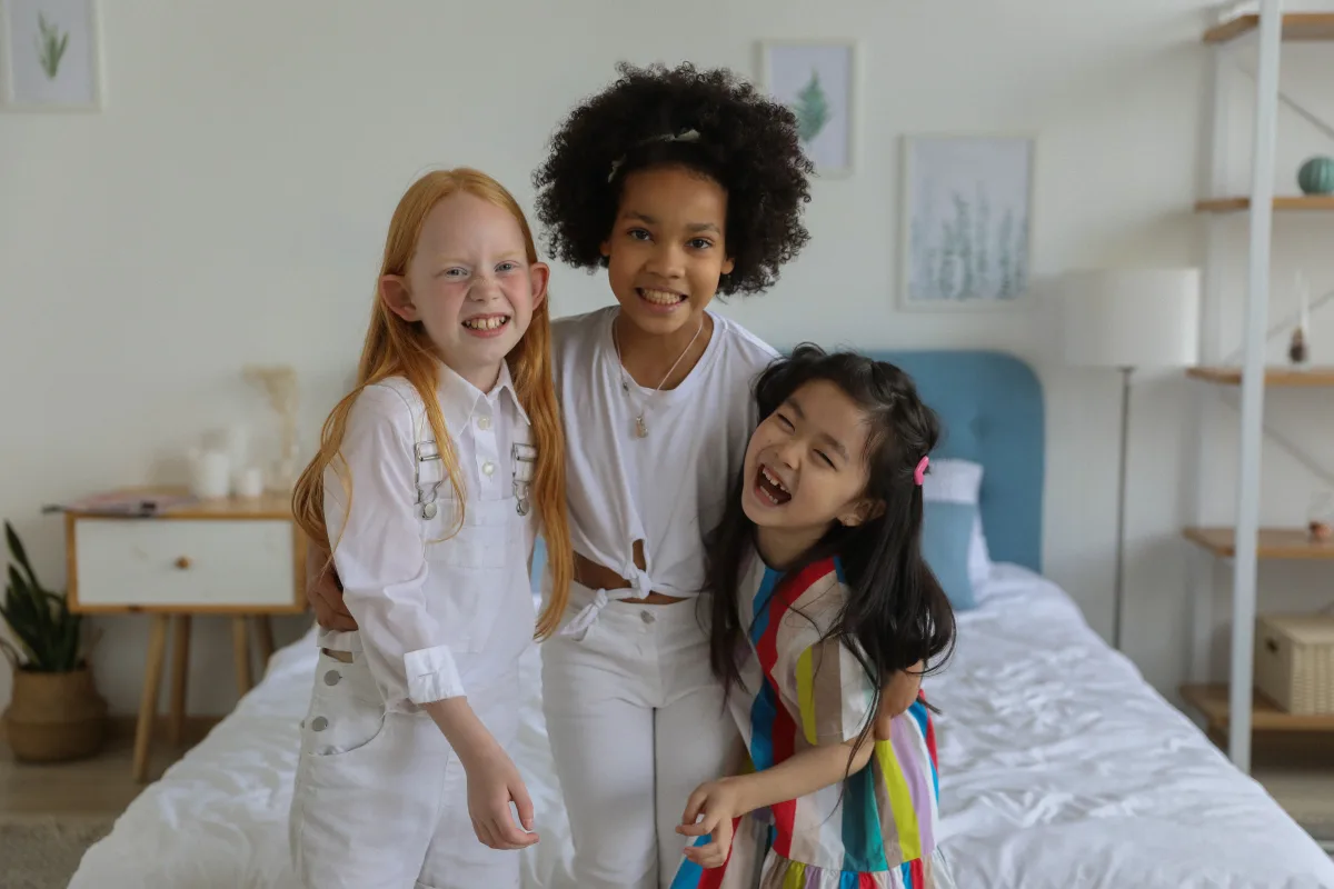 Group of diverse girls in bright outfits sitting together indoors