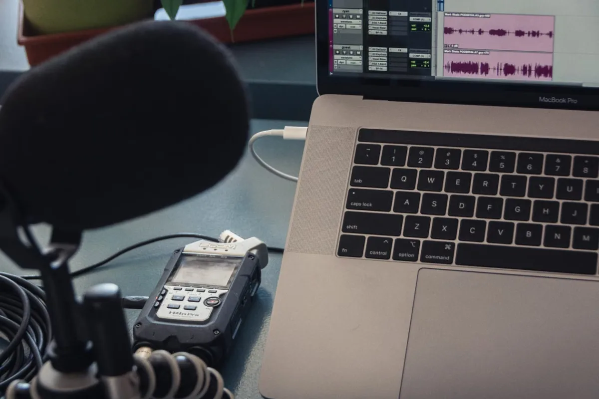 Close-up of a microphone and laptop in a home podcast recording setup