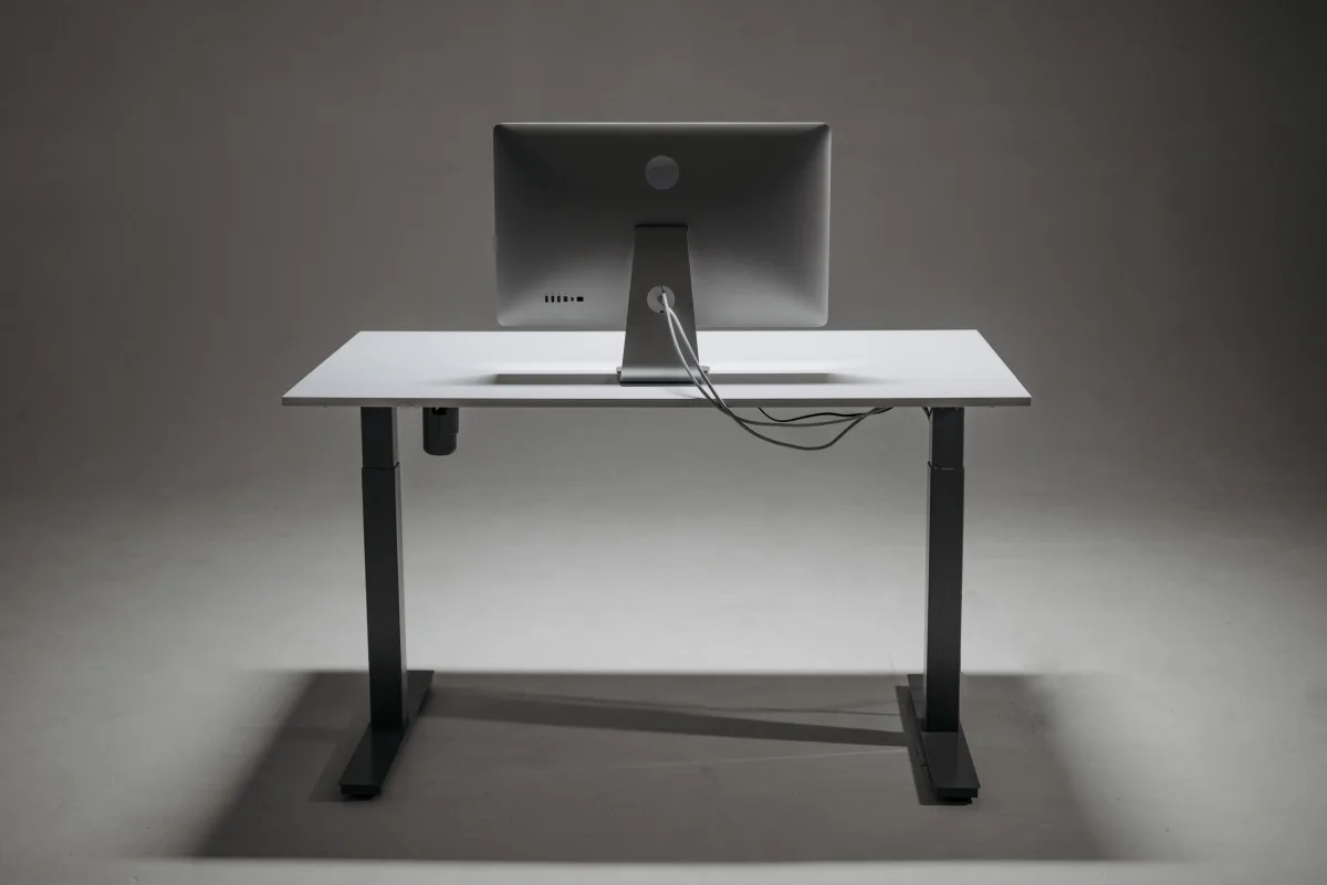Height-adjustable standing desk with monitor in a home office