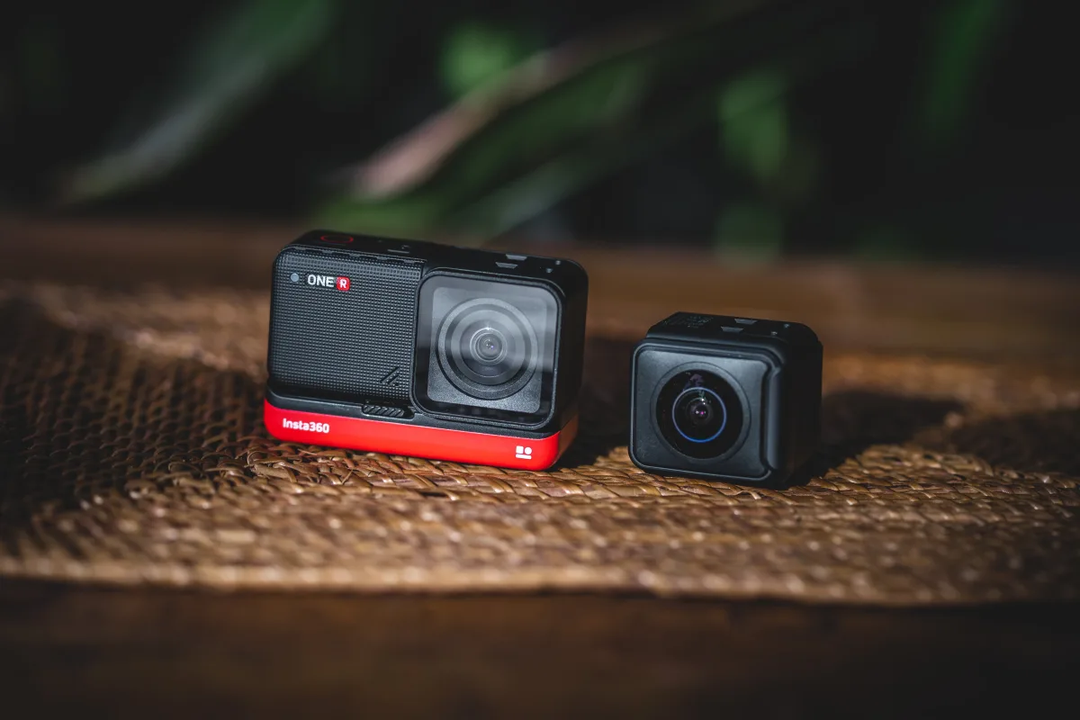 Two compact action cameras on a table showing front and rear camera pair