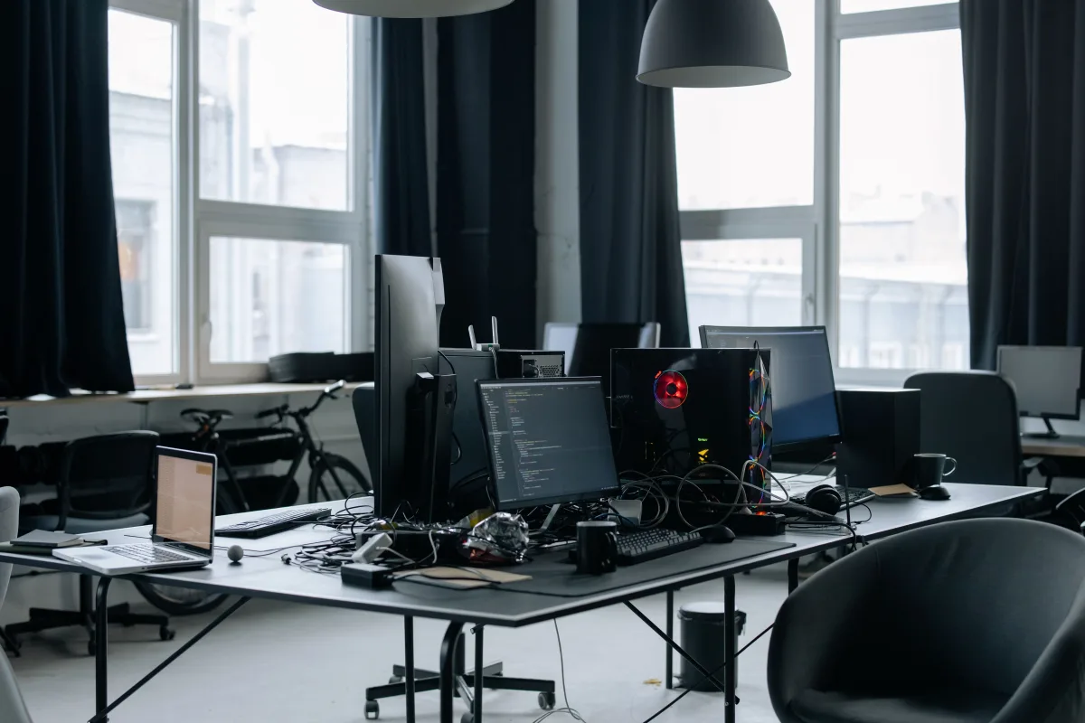 Tech-enabled workspace with coding screens and office essentials representing software-first planning