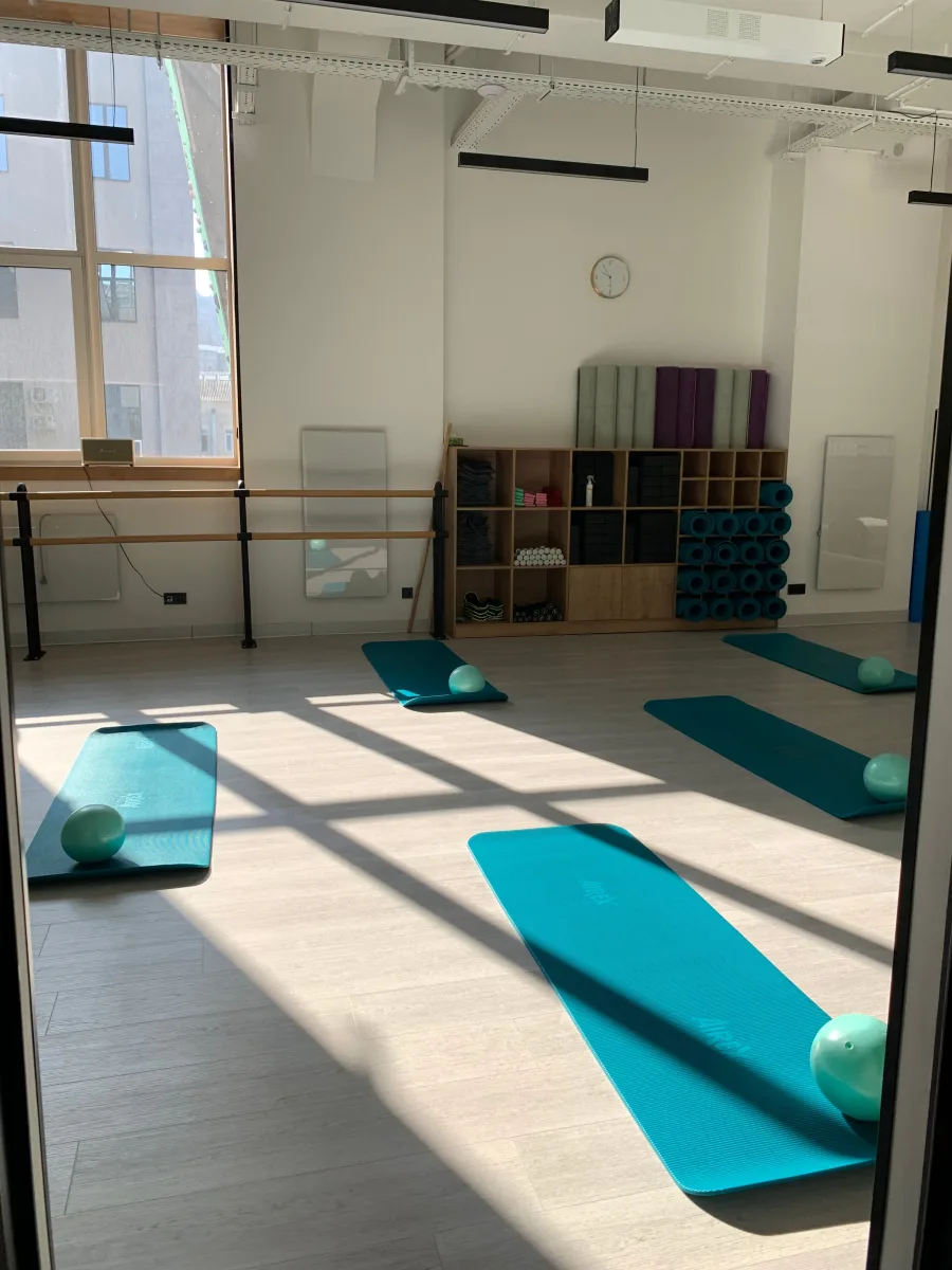 Bright Pilates studio with mats, balls, and props under natural light