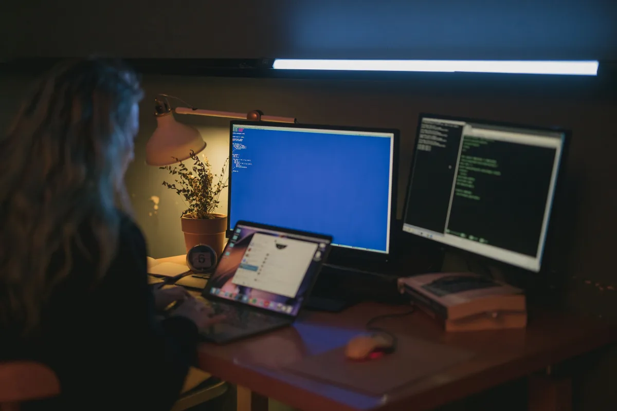 Person working on multiple monitors in a home office productivity setup