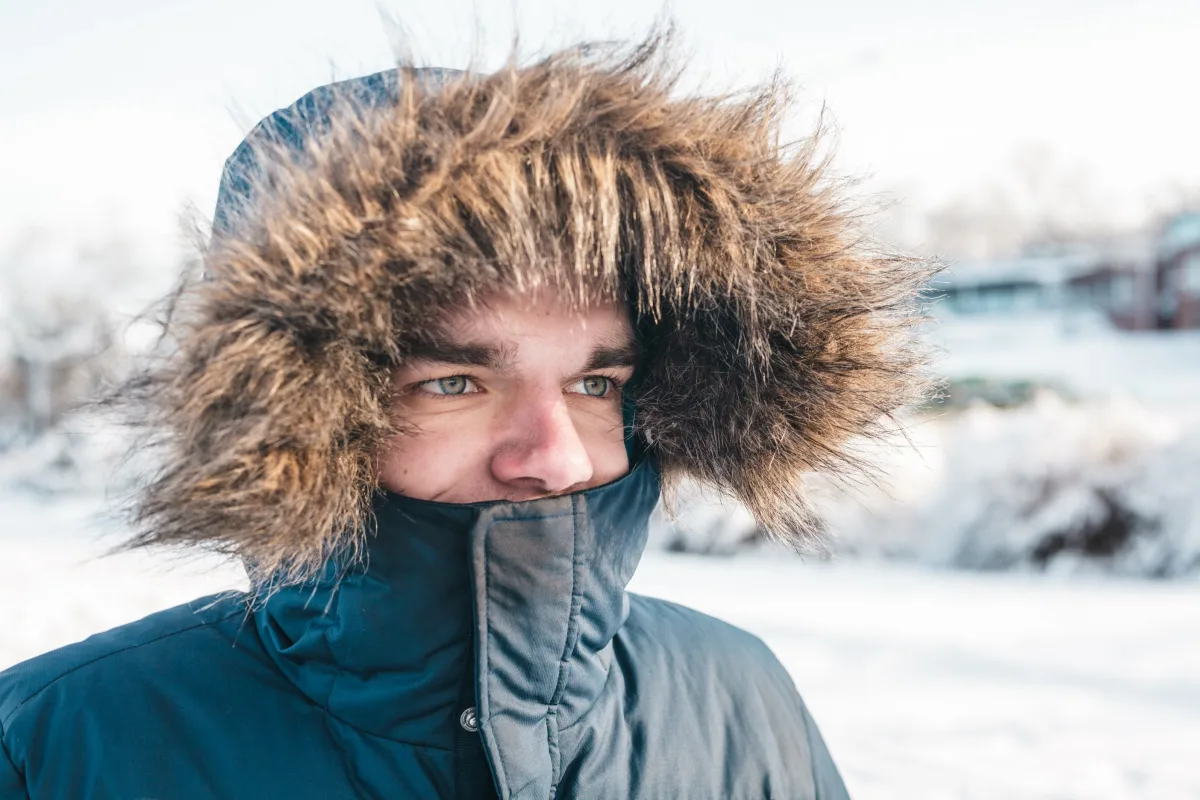 Man in heavy fur-lined expedition parka in snow