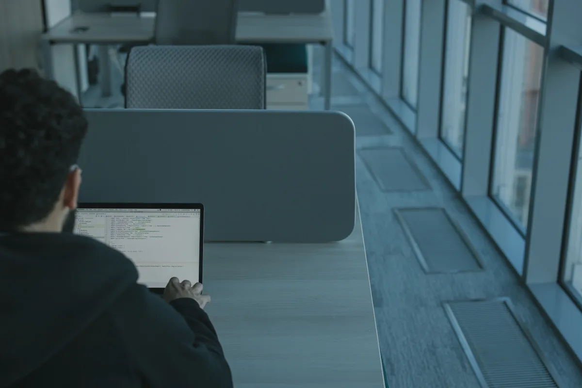 Person working on a laptop in a modern, low-paper office setting