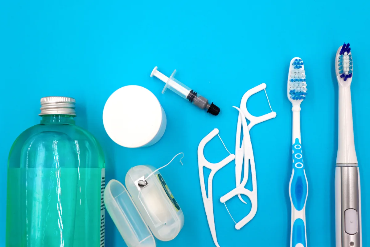 Oral hygiene tools — electric toothbrush, floss, and toothpaste