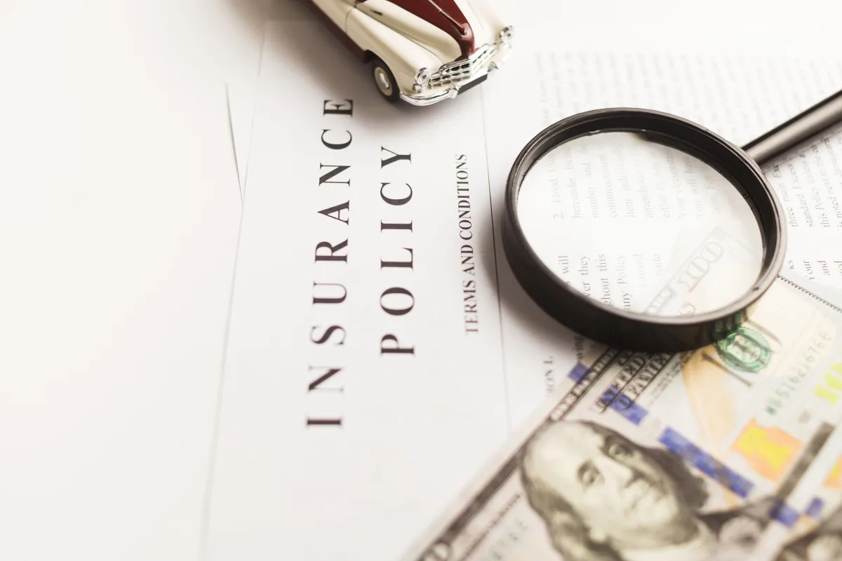 Close-up of a travel insurance policy document on a desk with a pen
