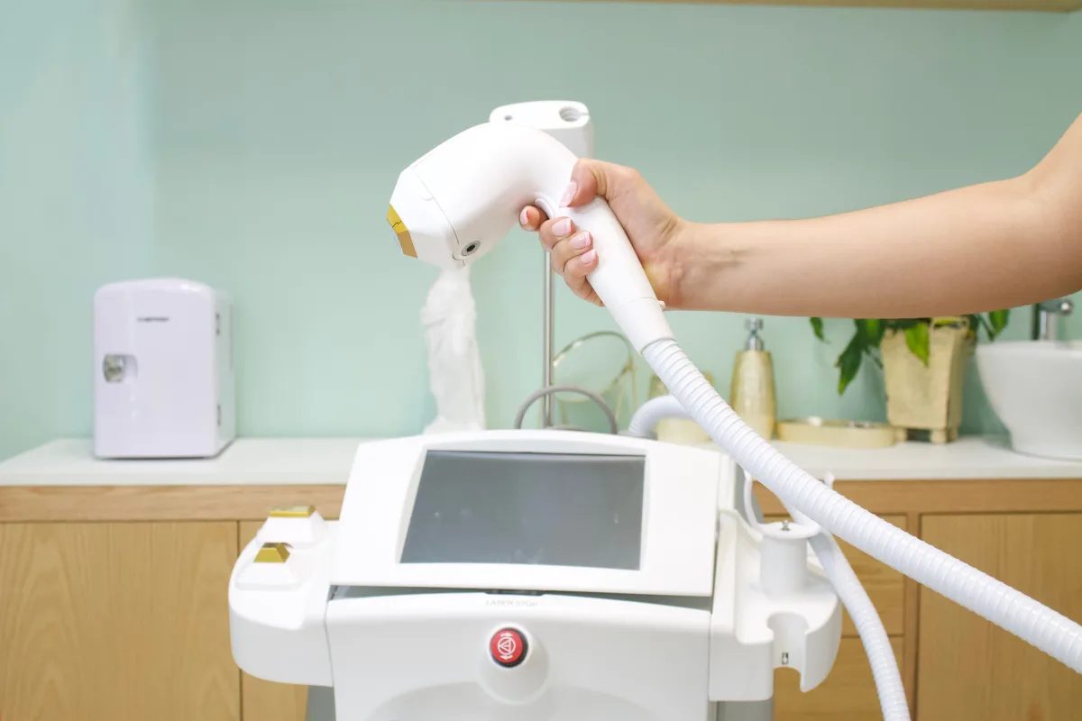 Close-up of person holding a laser/IPL hair removal device