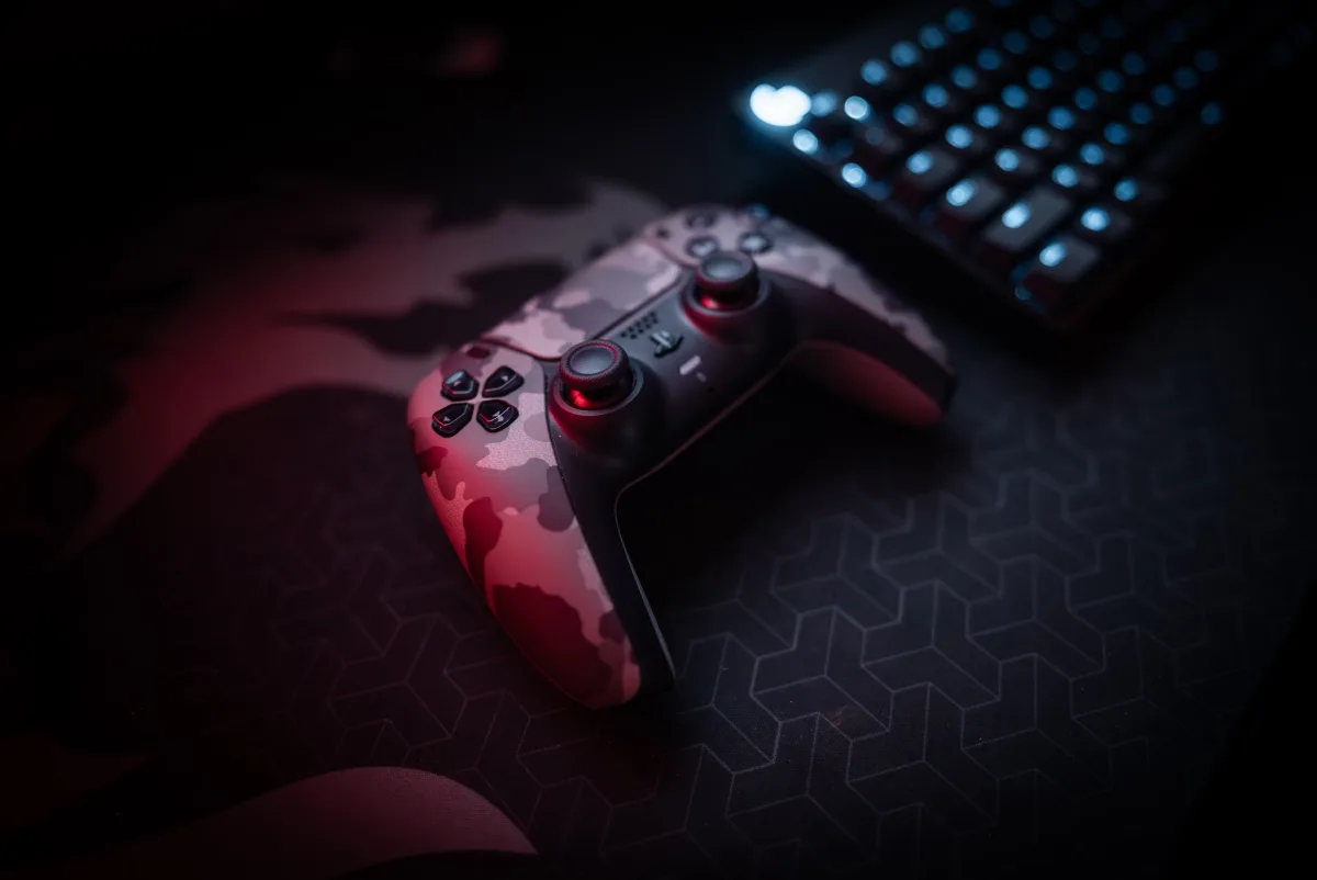 Close-up of a gaming controller and RGB keyboard representing console and PC gaming inputs
