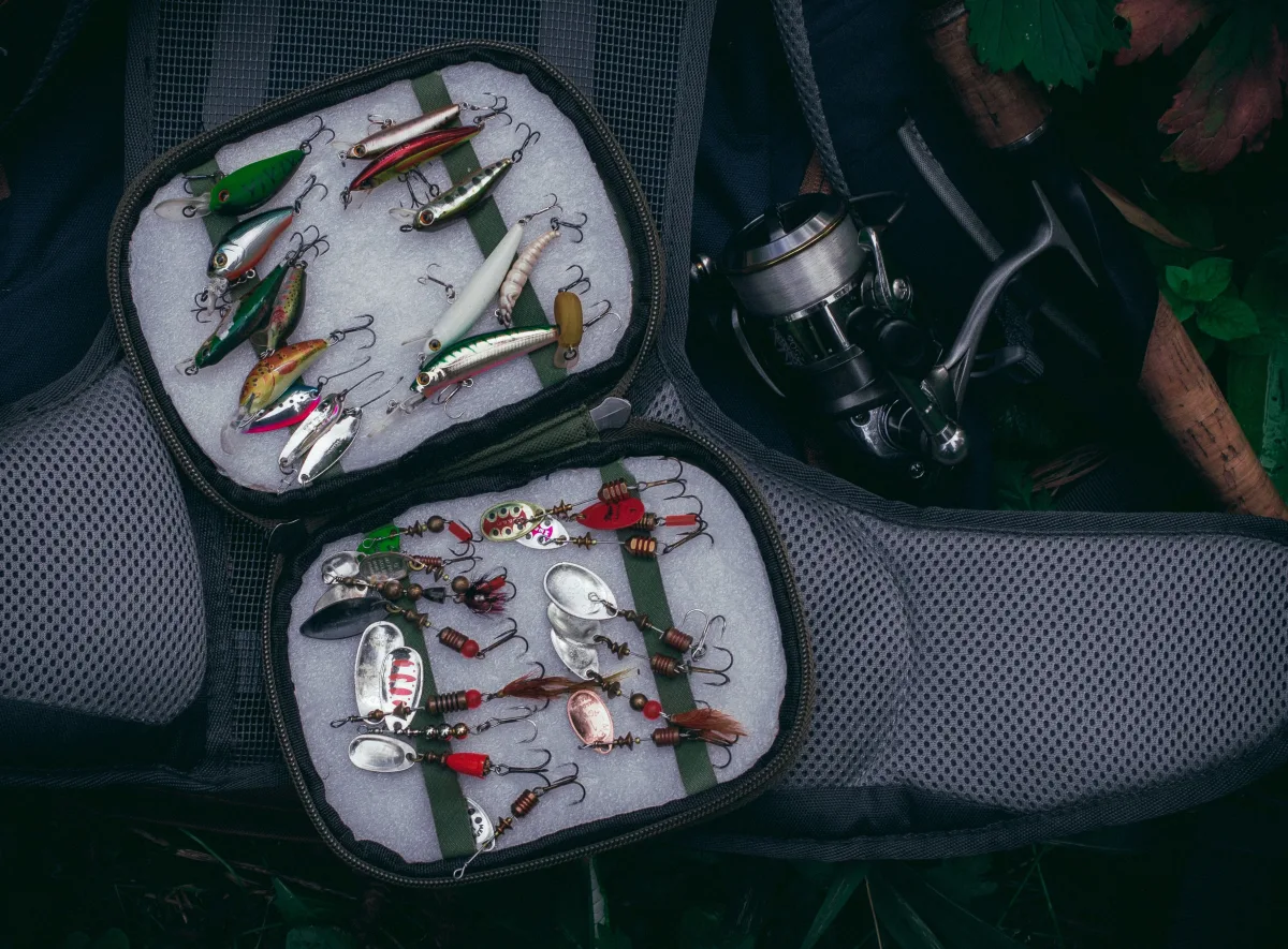 Top view of organized fishing kit with reel and colorful lures