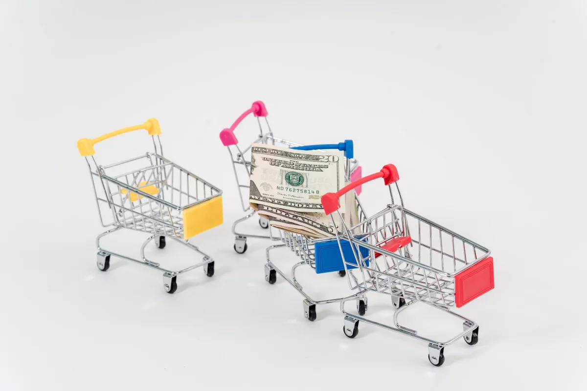 Colorful miniature shopping carts with dollar bills