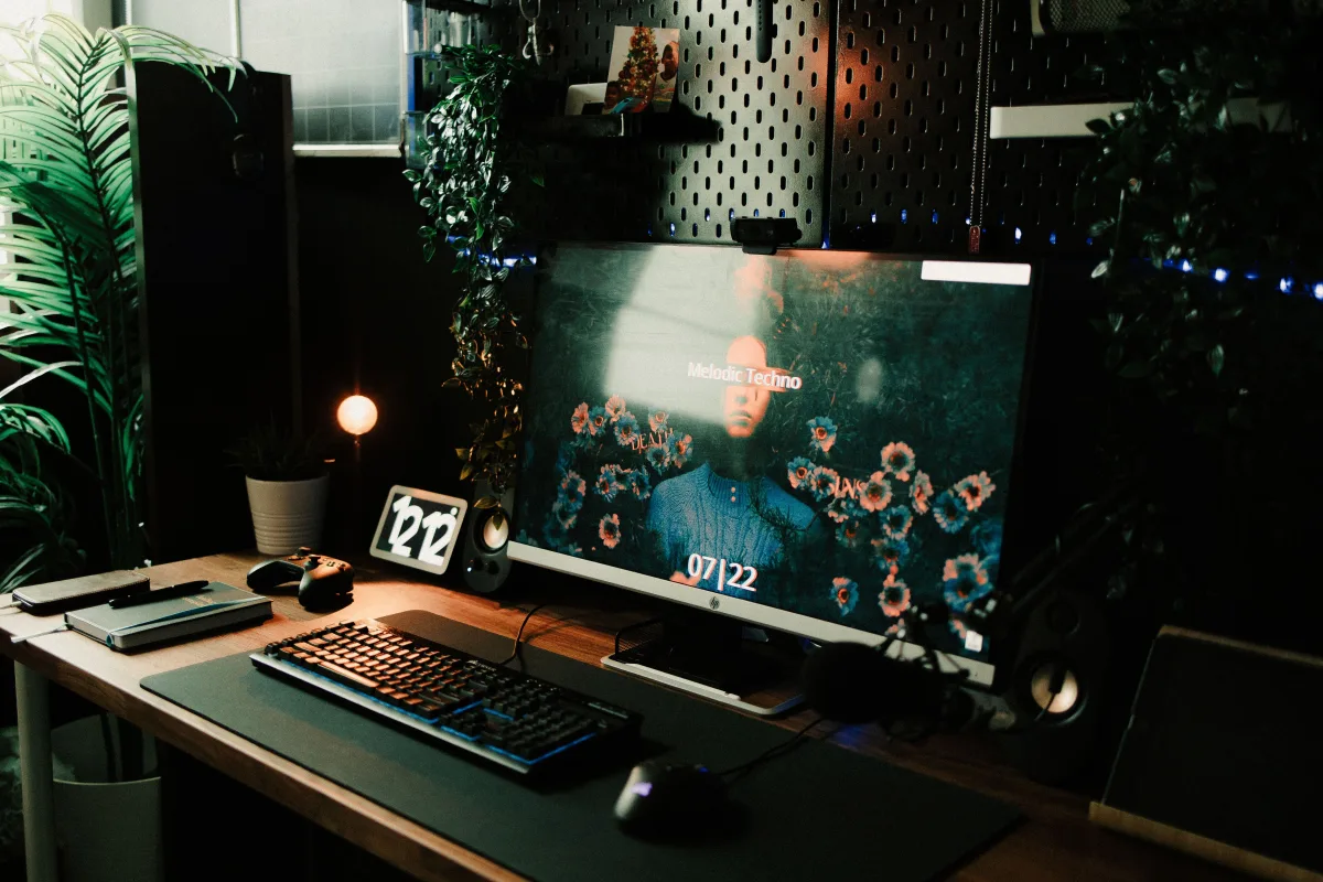 Stylish home office setup with monitor, keyboard, notebook, and plants