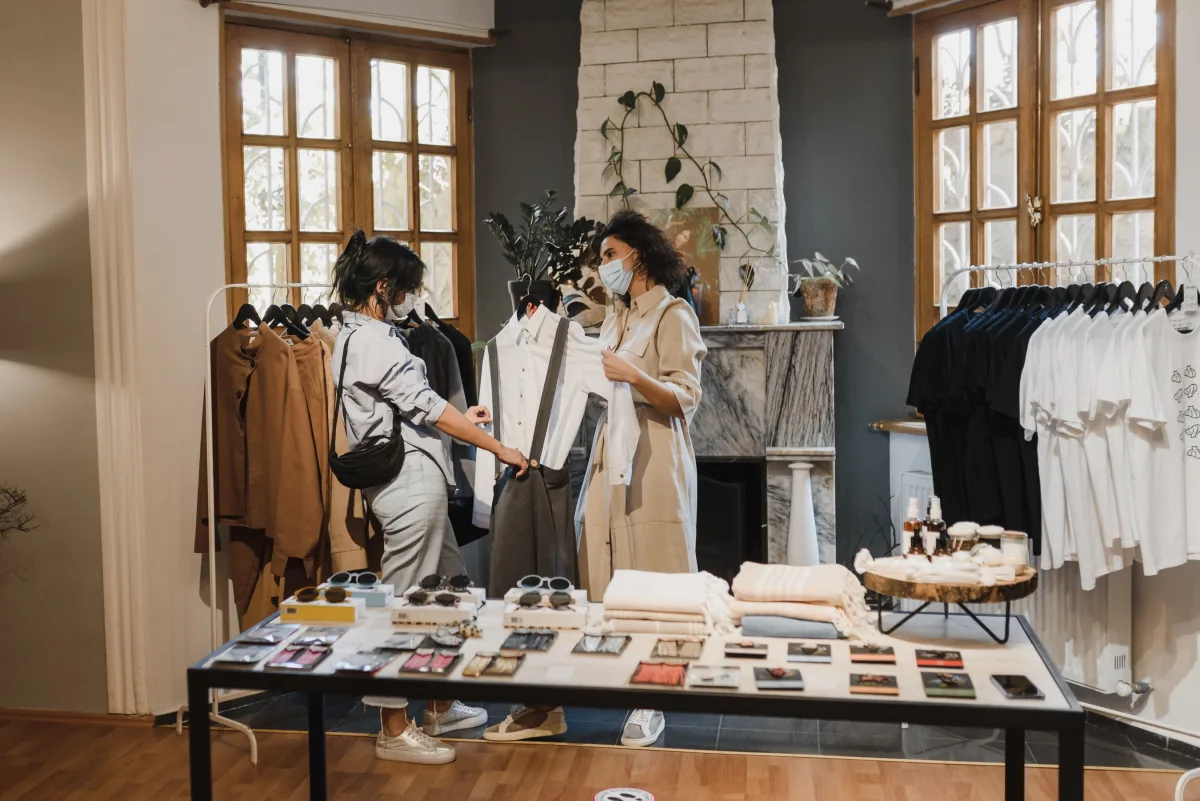 Two shoppers comparing clothes in a boutique