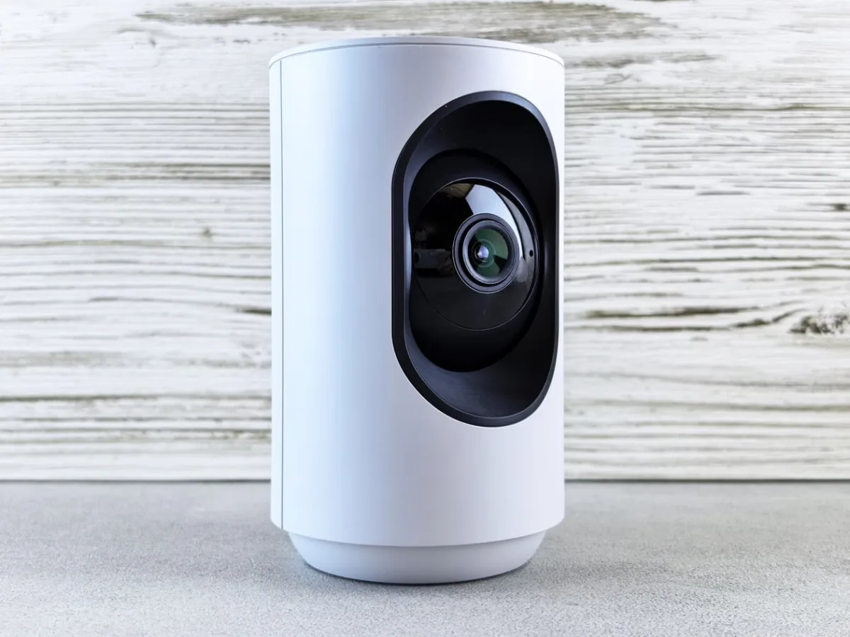 Close-up of a white indoor security camera mounted on a wall