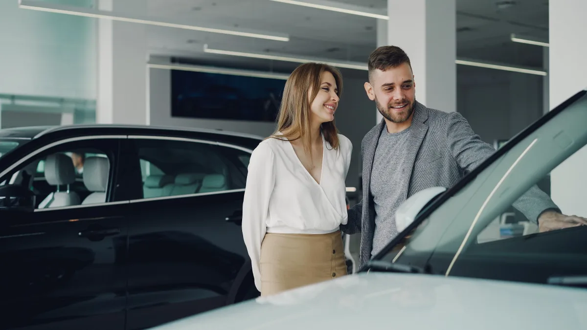 Couple browsing car options at dealership before making a decision