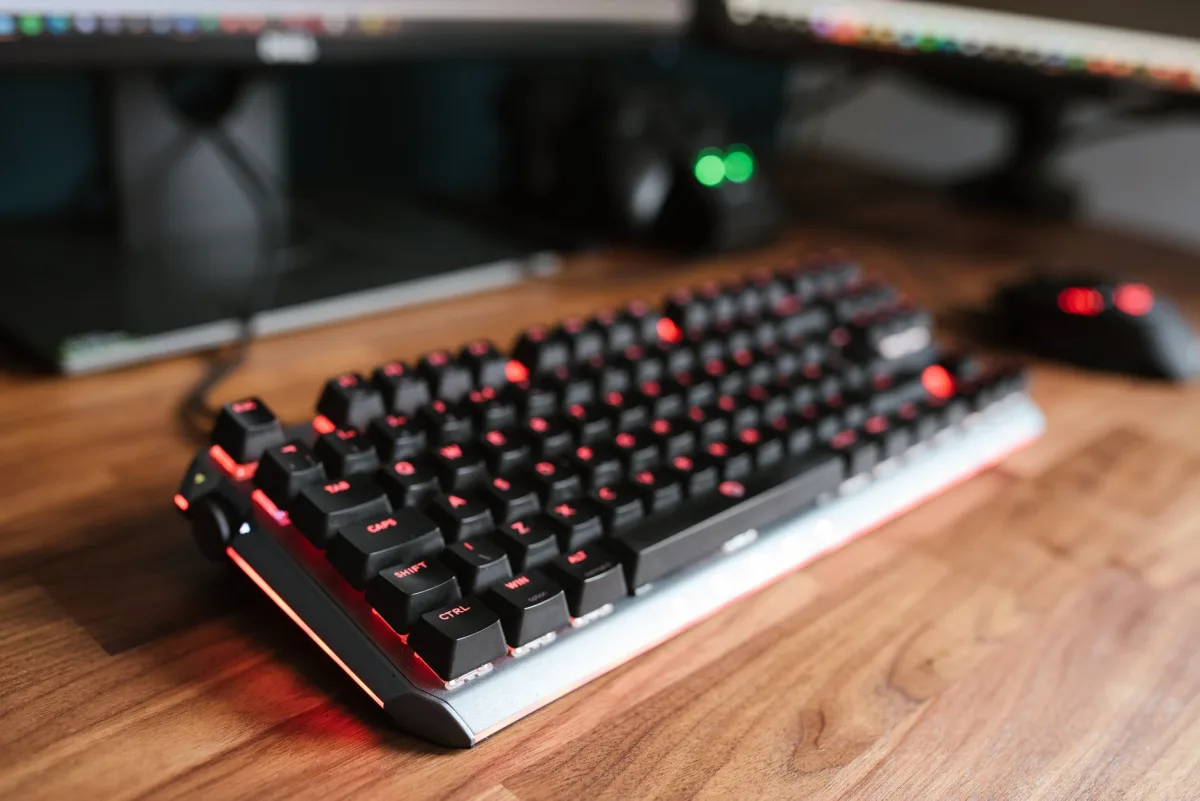 Contemporary backlit keyboard on wooden desk with mouse