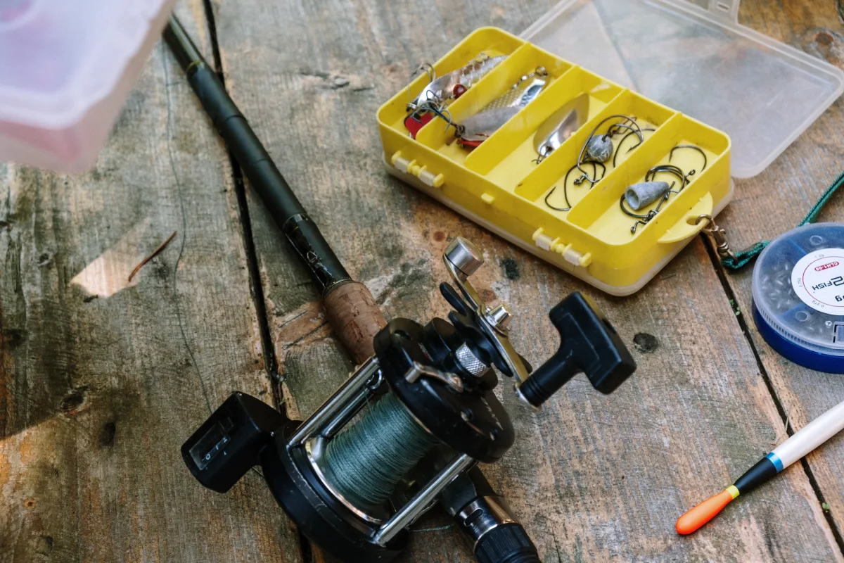 Close-up of spinning fishing rod and reel on wooden surface