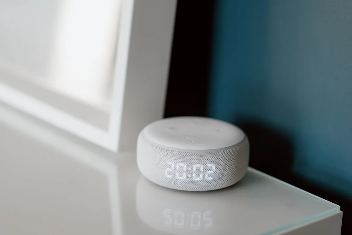 Close-up of smart speaker displaying 20:02 LED clock on a desk — Matter cross-platform smart home protocol 2026