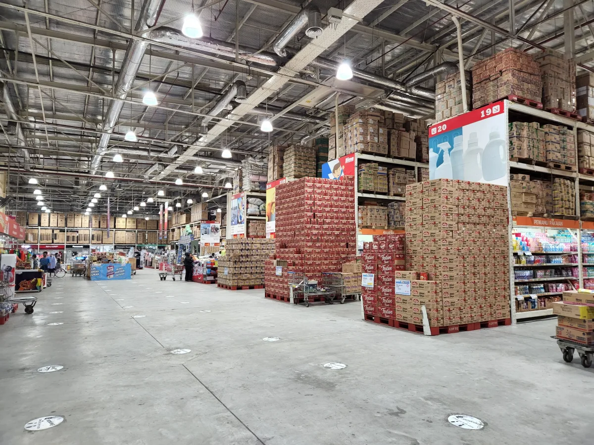 Large wholesale warehouse interior with stacked merchandise and shopping carts