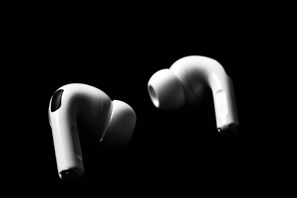 Sleek white wireless earbuds against a black background