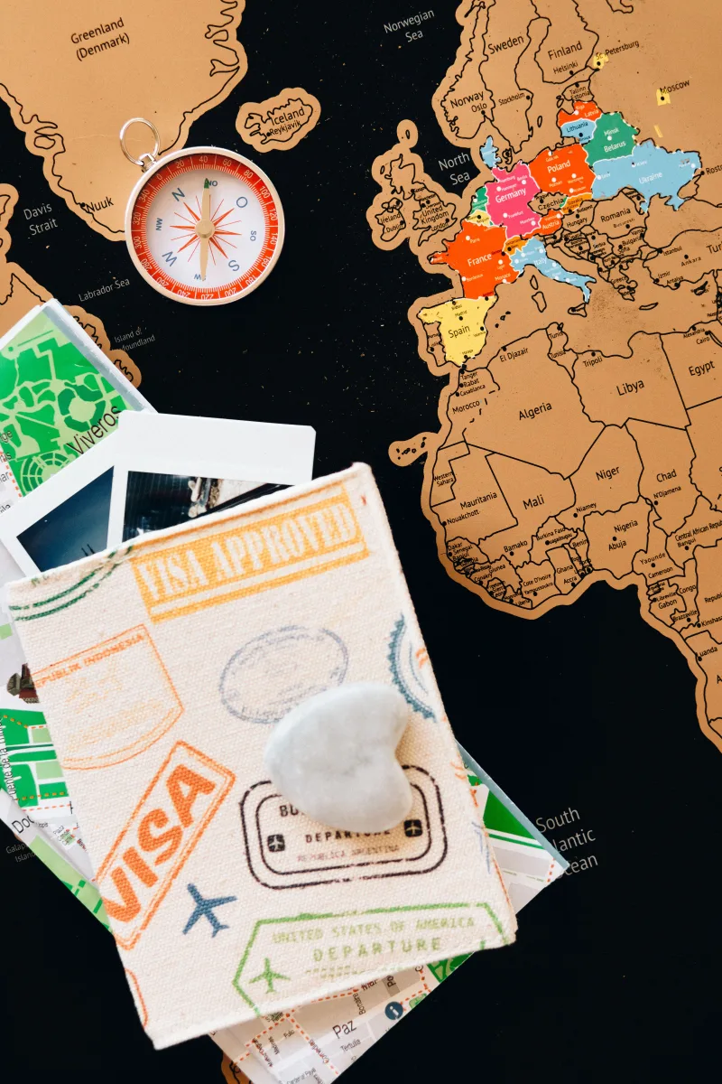 Passport with world map and polaroid pictures — travel planning concept