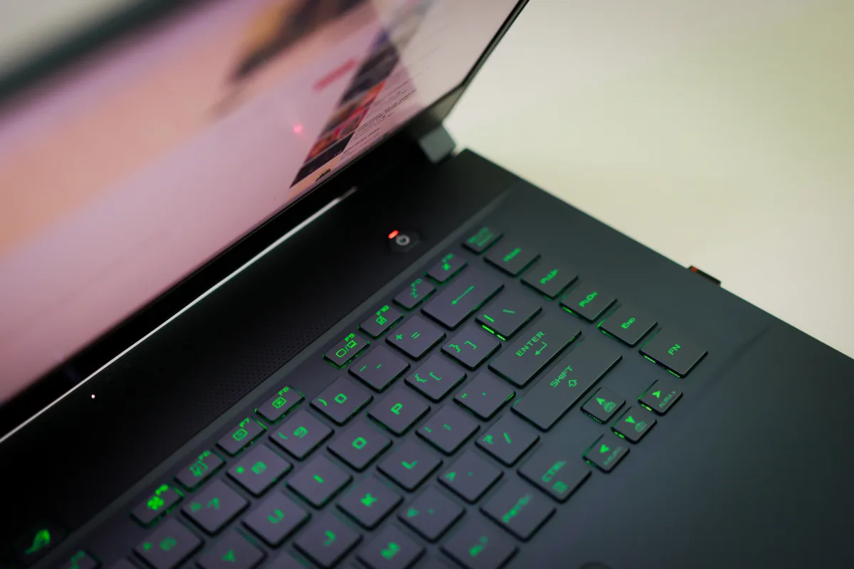Sleek laptop with glowing green RGB keyboard — gaming laptop GPU performance vs desktop 2026