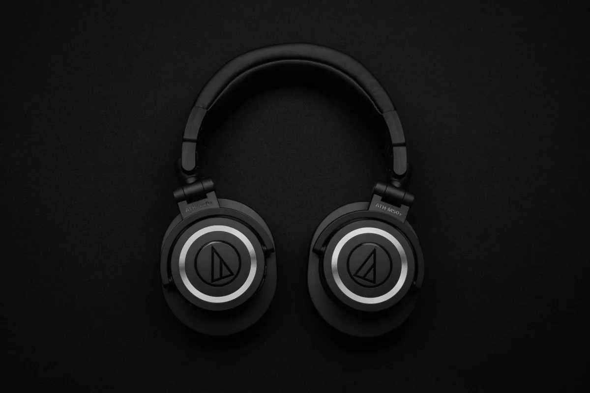 Close-up of black over-ear headphones on a black background